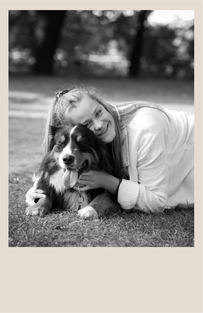 EIn schwarz weißes Bild von einer jungen Frau mit Hund in einem Polaroid-Rahmen